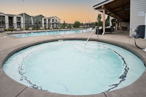 Happy Valley apartment for rent - a large resort style swimming pool with a building in the background at Sonder Fields in Happy Valley, OR