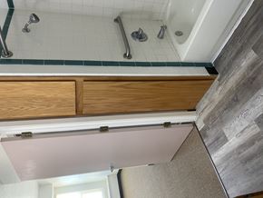 Grants apartment for rent - a bathroom with a shower and wooden cabinets