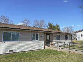 Dickinson apartment for rent - A house with a brown roof and a grey siding with a black door and a small porch.