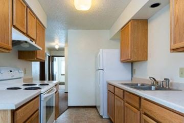 Dickinson apartment for rent - A kitchen with wooden cabinets and a white refrigerator.