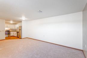Minot apartment for rent - A large empty room with a kitchen visible in the background.