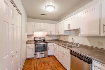 Minot apartment for rent - A kitchen with white cabinets and stainless steel appliances.