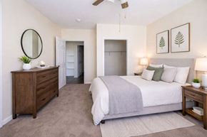 Decatur apartment for rent - A bedroom with a large bed, a dresser, and a mirror.