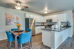 Saukville apartment for rent - A kitchen with a table and chairs and a fridge.