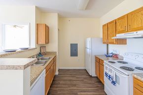 Decatur apartment for rent - A kitchen with wooden cabinets and a white stove top oven.