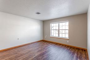 Minot apartment for rent - A room with a window and wooden flooring.