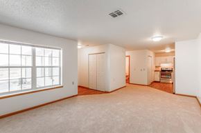 Minot apartment for rent - A spacious room with a window, a door, and a kitchenette.