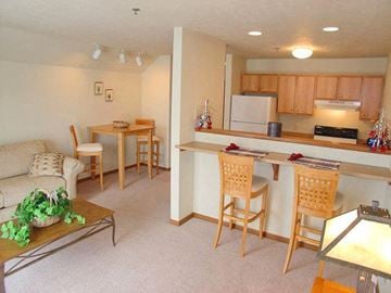 Neenah apartment for rent - a living room and kitchen with a table and chairs