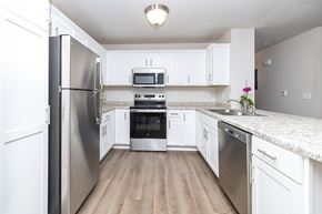 Oshkosh apartment for rent - A kitchen with white cabinets and stainless steel appliances.