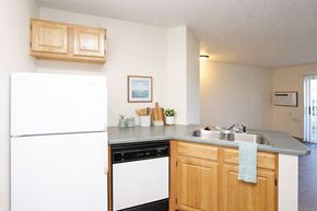 Newton apartment for rent - A kitchen with a white fridge and wooden cabinets.