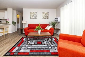 Oshkosh apartment for rent - A living room with a red couch and a black and red rug.