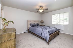 Oshkosh apartment for rent - A bedroom with a bed, dresser, and ceiling fan.