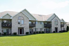 Neenah apartment for rent - a large house with a green lawn in front of it
