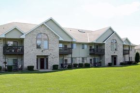 Neenah apartment for rent - a large house with a green lawn in front of it