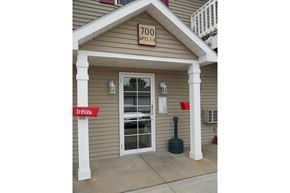 Viroqua apartment for rent - the front of a building with a door and a sign that says too time