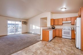 Neenah apartment for rent - A kitchen with white appliances and wooden cabinets.