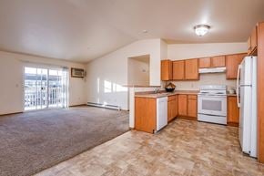 Neenah apartment for rent - A kitchen with white appliances and wooden cabinets.