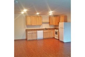 Viroqua apartment for rent - an empty kitchen with wooden cabinets and a white refrigerator