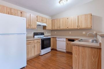 Stevens Point apartment for rent - A kitchen with wooden cabinets and a white refrigerator.
