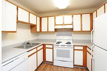 Grinnell apartment for rent - A kitchen with white appliances and wooden cabinets.