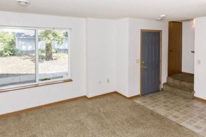 Waseca townhouse for rent - an empty living room with a blue door and a window