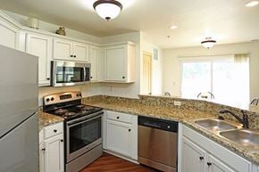 Waukesha apartment for rent - a kitchen with stainless steel appliances and white cabinets