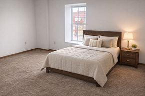 Hartford City apartment for rent - A bedroom with a bed, nightstand, and window.
