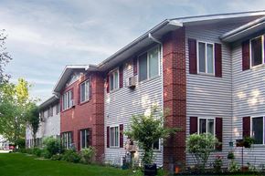 Green Bay apartment for rent - a red brick house with white siding and a yard