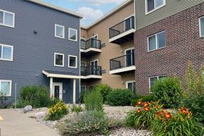 Viroqua apartment for rent - A building with a grey facade and a balcony with a black railing.