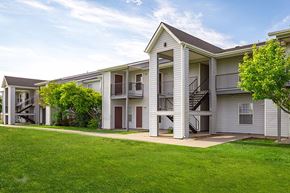 Hugoton apartment for rent - A row of white apartment buildings with green lawns in front.