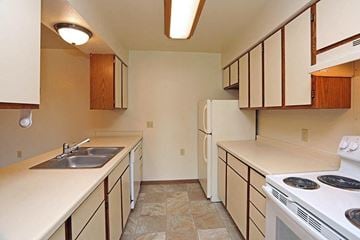 Manitowoc apartment for rent - A kitchen with white appliances and wooden cabinets.