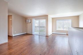 Stevens Point apartment for rent - A room with wooden floors and a sliding glass door leading to a balcony.