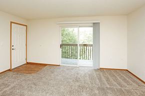 Grinnell apartment for rent - A room with a carpeted floor and a sliding glass door leading to a balcony.