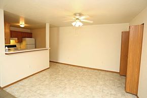 Neenah apartment for rent - an empty living room and kitchen with a ceiling fan
