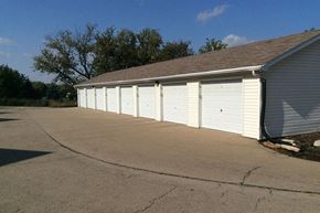 Chilton apartment for rent - a row of white garage doors on the side of a building