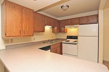 Fond Du Lac apartment for rent - a kitchen with white appliances and wooden cabinets