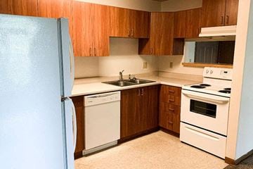 Mahomet apartment for rent - a kitchen with white appliances and wooden cabinets and a refrigerator