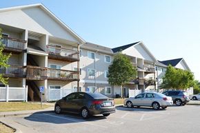 Le Claire apartment for rent - an apartment building with cars parked in a parking lot