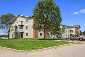 Oskaloosa apartment for rent - Apartment building with a tree in front and a car parked in the driveway.