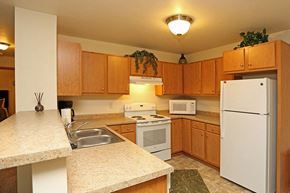 Fond Du Lac apartment for rent - A kitchen with wooden cabinets and a white refrigerator.