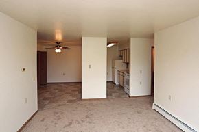 Manitowoc apartment for rent - A room with a ceiling fan and carpeted floor.