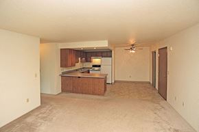Fond Du Lac apartment for rent - an empty living room and kitchen with a ceiling fan