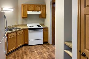 Greenfield apartment for rent - A kitchen with wooden cabinets and a white stove top oven.