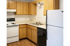 Marshalltown apartment for rent - A kitchen with wooden cabinets and white appliances.