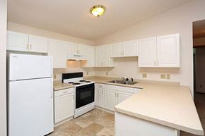 Beaver Dam apartment for rent - a kitchen with white cabinets and a stove and refrigerator