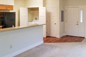 Spiceland apartment for rent - A kitchen area with a black fridge and white cabinets.