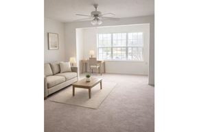 Sumter apartment for rent - A living room with a white sofa, a wooden coffee table, and a ceiling fan.