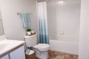 Riverside apartment for rent - A white toilet sits next to a sink in a bathroom.