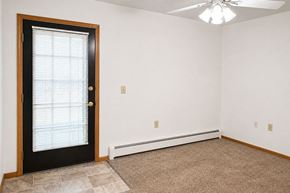 Fond Du Lac apartment for rent - A room with a black door and a ceiling fan.