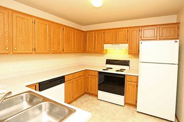 Neenah apartment for rent - a kitchen with white appliances and wooden cabinets
